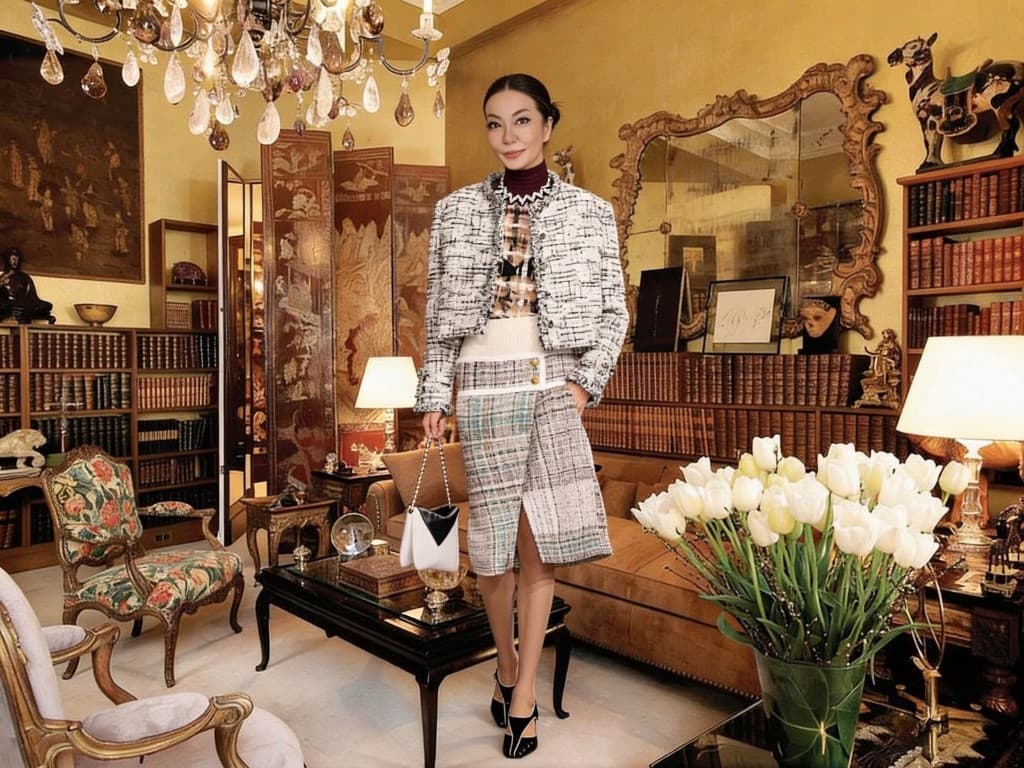 Editorial fashion portrait in a tweed suit inside a richly furnished library salon